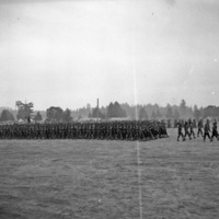 A long line of over a hundred soldiers walking in formation.  A tent camp can be seen in the background.