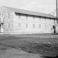A two-story building with eight windows on each level, flanked by other, similar buildings.