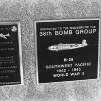 A close-up of a plaque set in a series of plaques.  Other plaques can be seen to the left of the centered one.  
