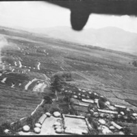 Farming fields and buildings, with the perspective from above in the back of an aircraft.