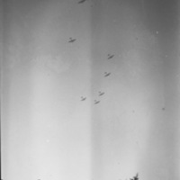 Seven planes are seen flying in the sky flying in formation.