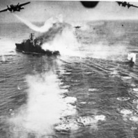 Three bombing planes dropping bombs on a naval battleship on the open water.