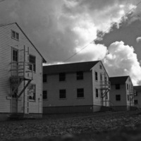 A series of six two-story buildings, with platform exits on the second floors leading to a ladder that allows access from the ground.