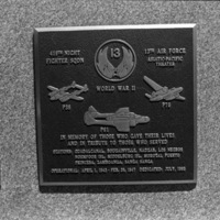 A close-up of a plaque set in a series of plaques.  Other plaques can be seen to the left of the centered one. 