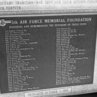 A close-up of a memorial plaque with two long lists of military units being memorialized.  Many are not readable due to low resolution.