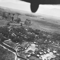 Farming fields and buildings, with the perspective from above in the back of an aircraft.