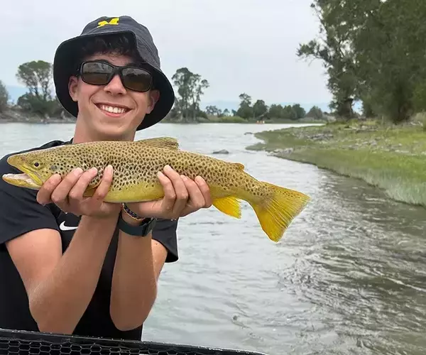 									Bozeman fly fishing trip brown trout and happy angler on the yellowstone river
															