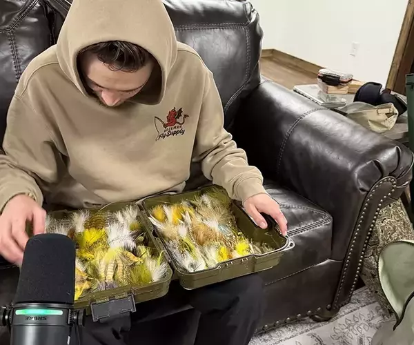 									Alex swank inspecting streamers for fly fishing the wind river
															