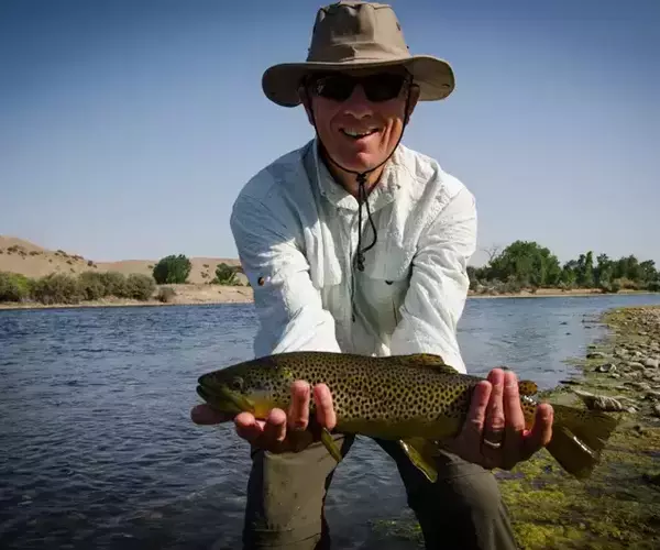 									Angler fishing the Bighorn River Montana with a nice Montana Brown Trout
															