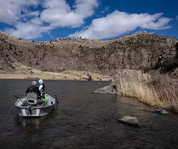 									Madison river fly fishing anglers resting in driftboat
															