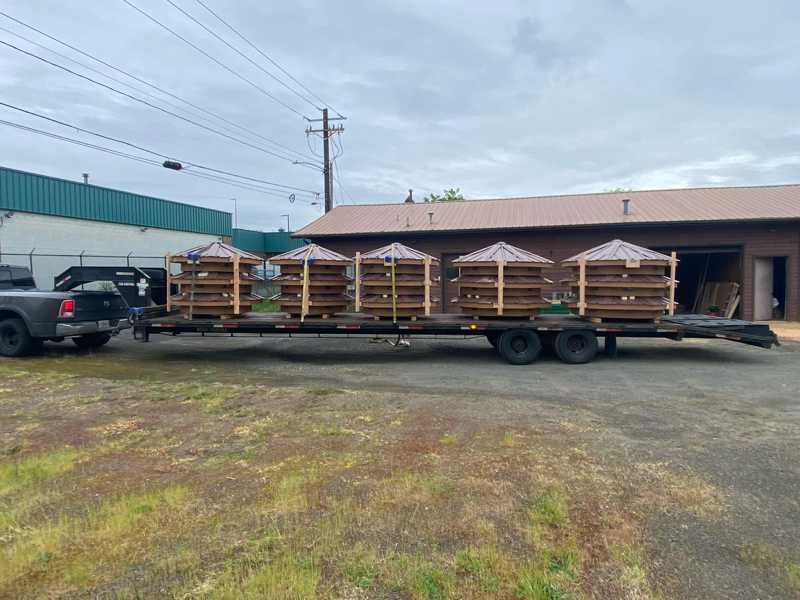 Flatbed trailer loaded with strapped wooden yurts ready to move!