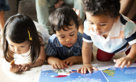 Children's paintings, displayed on a light green wall, are alongside text descriptions. The vibrant artworks include abstract designs and a photo of a child painting. Text describes the creative process.