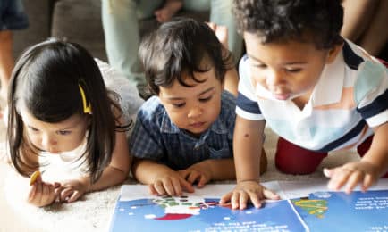 Children's paintings, displayed on a light green wall, are alongside text descriptions. The vibrant artworks include abstract designs and a photo of a child painting. Text describes the creative process.