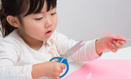 Children's paintings, displayed on a light green wall, are alongside text descriptions. The vibrant artworks include abstract designs and a photo of a child painting. Text describes the creative process.