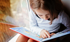 Children's paintings, displayed on a light green wall, are alongside text descriptions. The vibrant artworks include abstract designs and a photo of a child painting. Text describes the creative process.