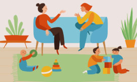 Adults sit conversing on a blue couch, while children play with toys on a green rug in a room with potted plants.