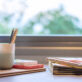 Preschool materials with pencils, children’s books, and colorful blocks organized neatly in front of a sunny window.