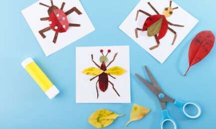 Colorful bug-themed art projects made with leaves on a blue background with scissors and glue.