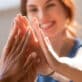 Group of women high five, while smiling and working together as a team.