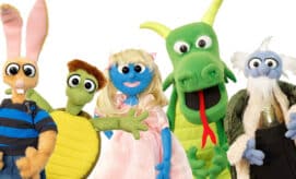 A group of puppet characters, including a princess and a dragon.