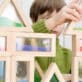 Young boy stacks colorful blocks together, exploring STEM concepts in an early learning classroom.