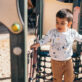 A young boy plays on outdoor play equipment.
