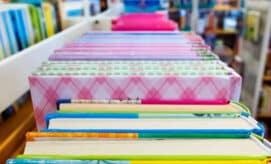 Colorful children's books sitting on a library book cart.