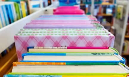 Colorful children's books sitting on a library book cart.