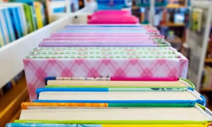 Colorful children's books sitting on a library book cart.