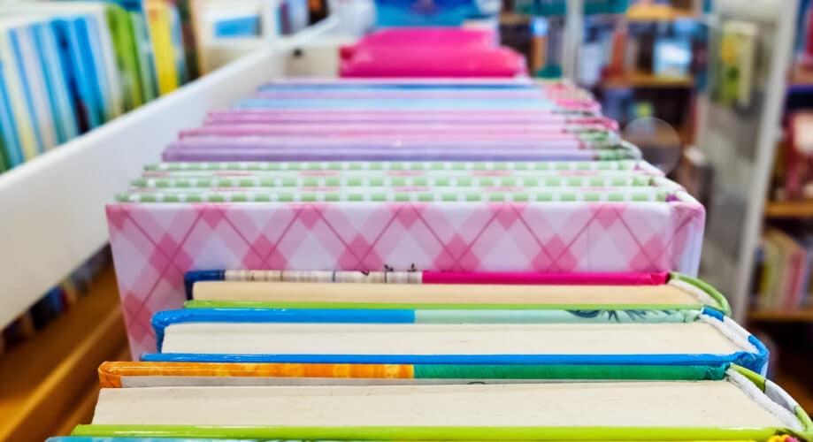 Colorful children's books sitting on a library book cart.