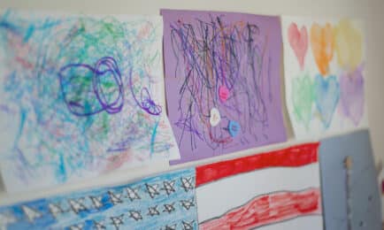 A young boy plays outdoors with a parachute.