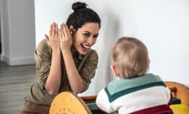 Caregiver and toddler play peek-a-boo together