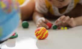 A young boy explores the planets with playdough and a globe.