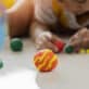 A young boy explores the planets with playdough and a globe.