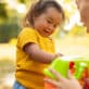 A toddler explores a toy with her caregiver.