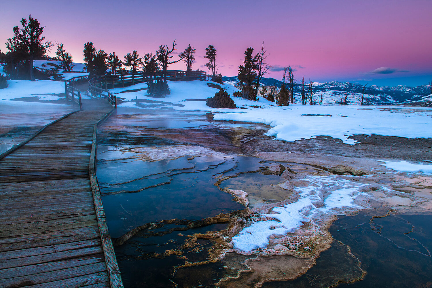  
											 Hot springs in Yellowstone National Park covered in a layer of snow
										  										 