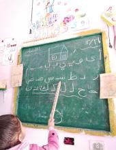 Home-based KG Madaba girl at blackboard.jpg