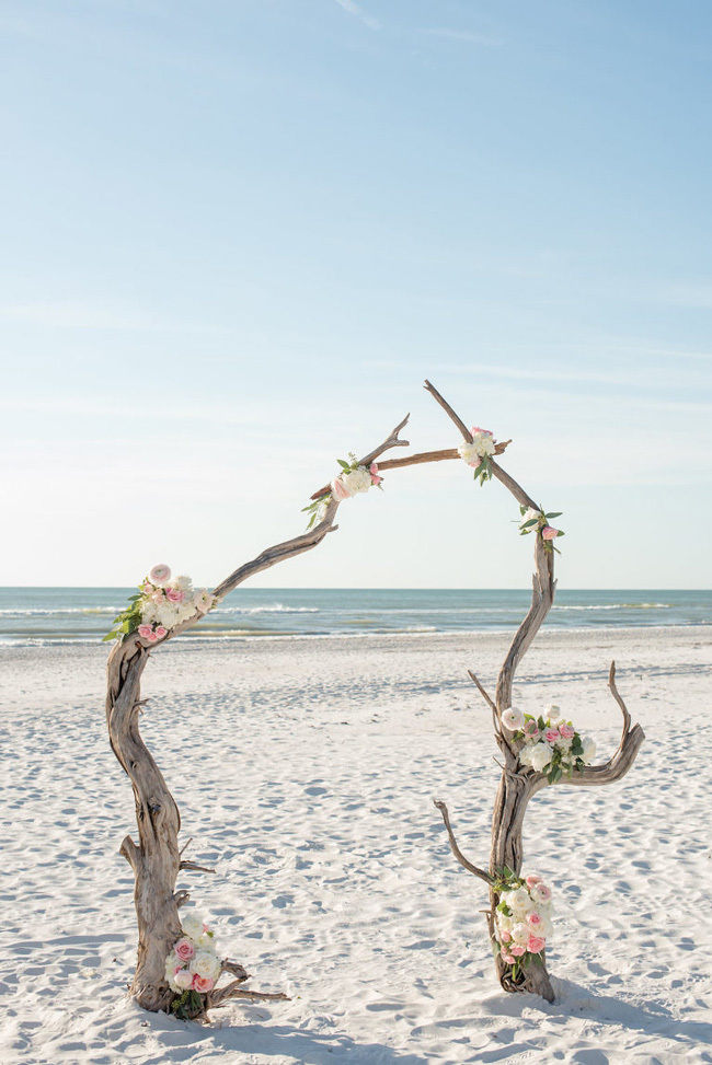 A simple driftwood wedding arch with flowers A simple driftwood wedding arch with flowers