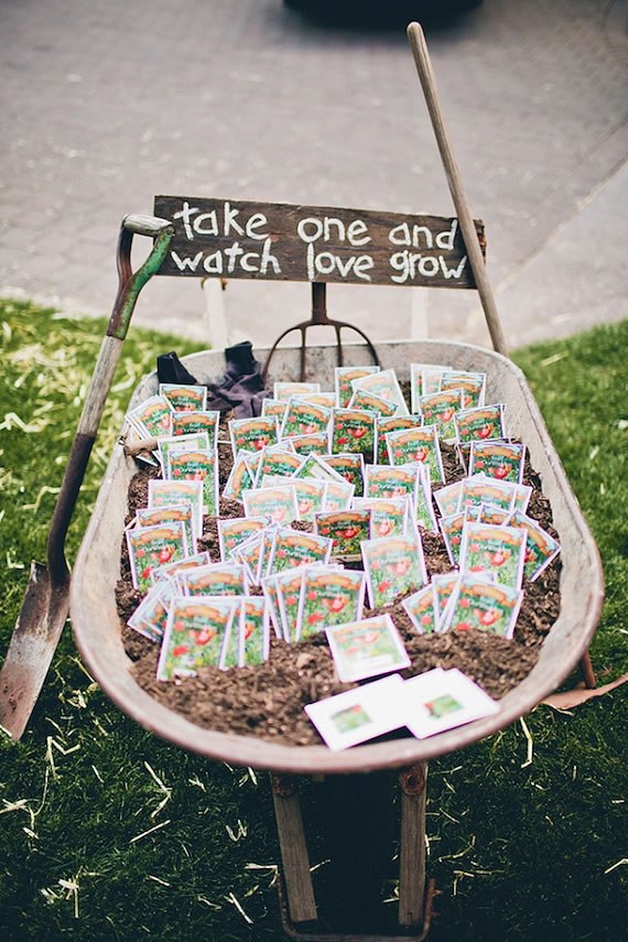 Seed packet wedding favors under $1 Seed packet wedding favors displayed in a rustic wheelbarrow