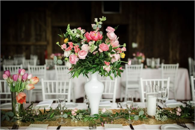 Bright florals and white decor dress up a barn wedding venue