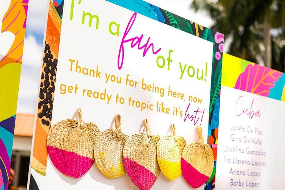 Neon colored seating chart with a tropical theme and color-dipped fans