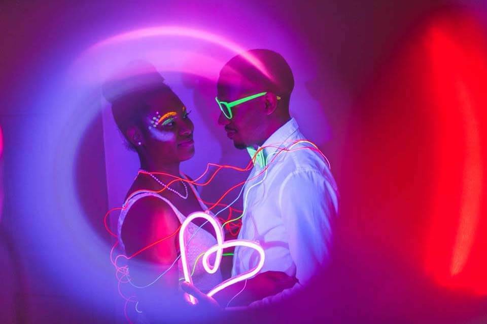 Newlyweds don glowing accessories and makeup for their blacklight reception