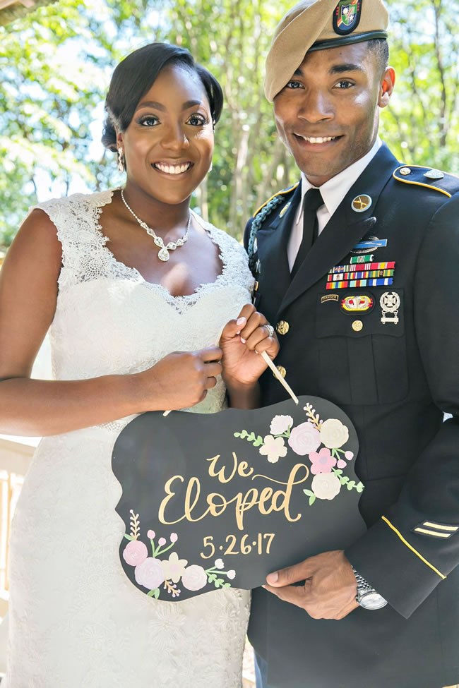 Military couple holding a 'We Eloped' sign