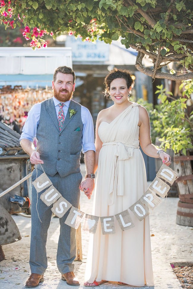 Bride and groom with a 'Just Eloped' burlap bunting