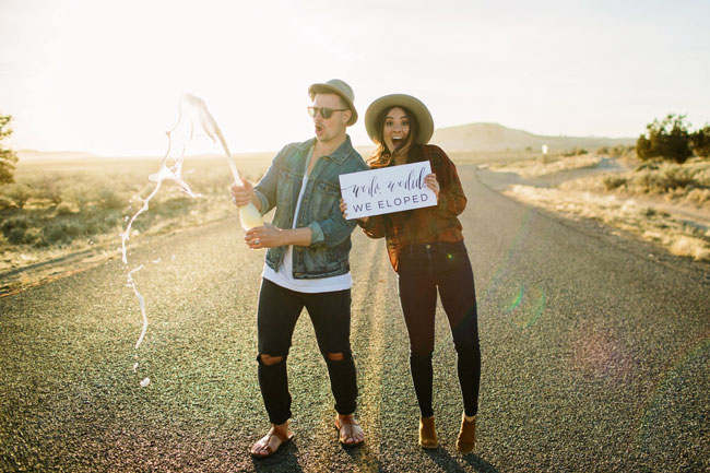 What To Think About Before You Elope Hipster couple popping champagne with a 'We Eloped!' sign