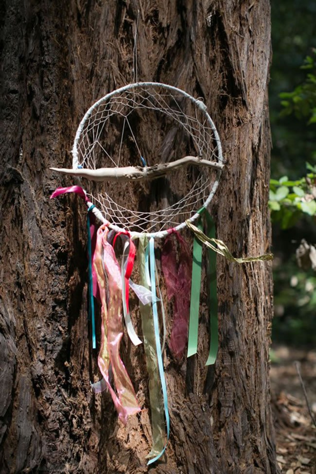 Dreamcatcher Wedding Decor by Vibrant Events A dreamcatcher on a redwood for rustic forest wedding decor