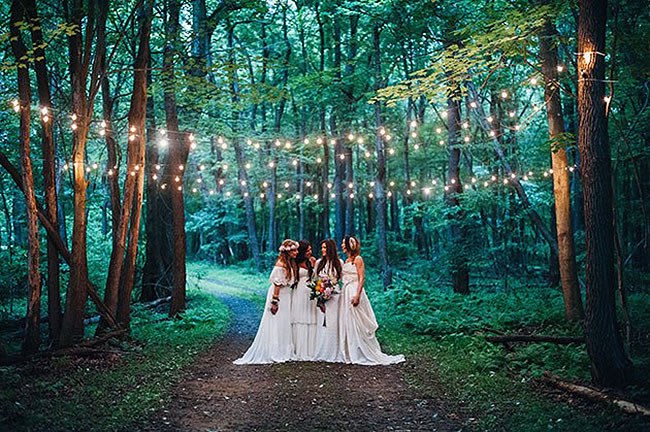 Forest wedding with bistro lights A forest wedding at twilight with strands of bistro lights
