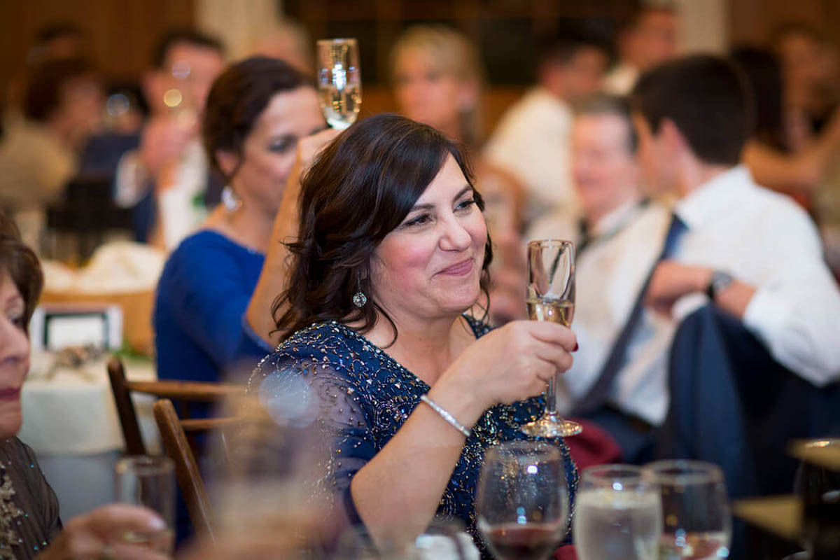 A wedding guest raises her glass in a toast