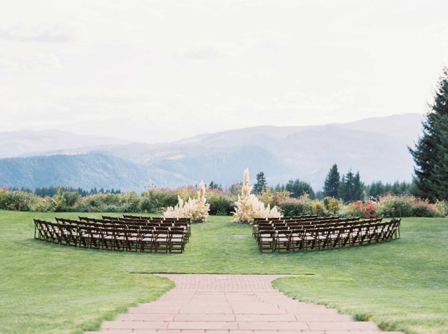 A stunning outdoor wedding ceremony with a view of the Columbia River Gorge and Hood River Valley at Gorge Crest Vineyards in Washington. 