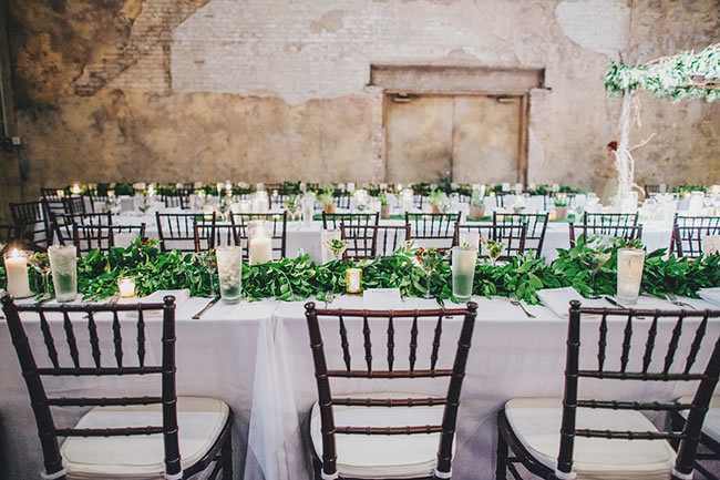 Long, white wedding tables with greenery runners Long, white wedding tables with greenery runners